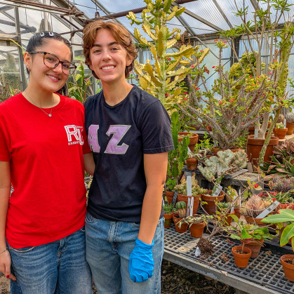 Students stand in a greenhouse