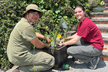 Student horticulturists add flowers to a planter